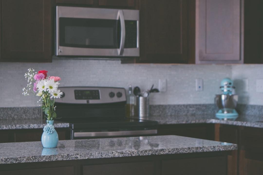 Flower arrangement on vase on kitchen island from Jessica Lewis 🦋 thepaintedsquare on Unsplash