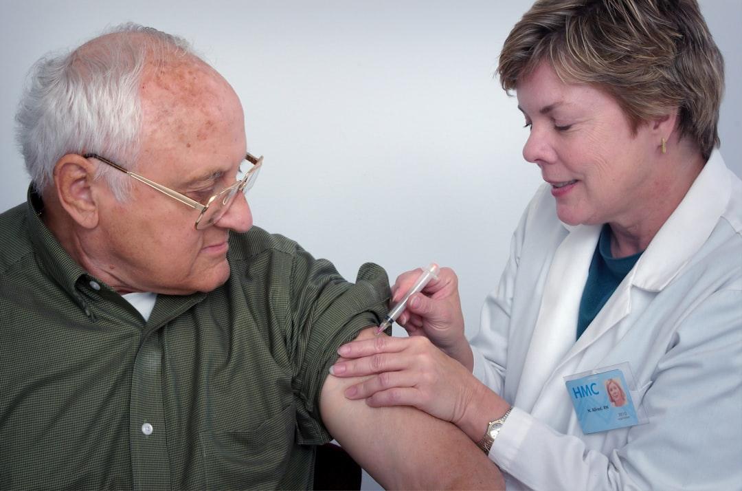Woman injecting syringe on mans arm from CDC on Unsplash