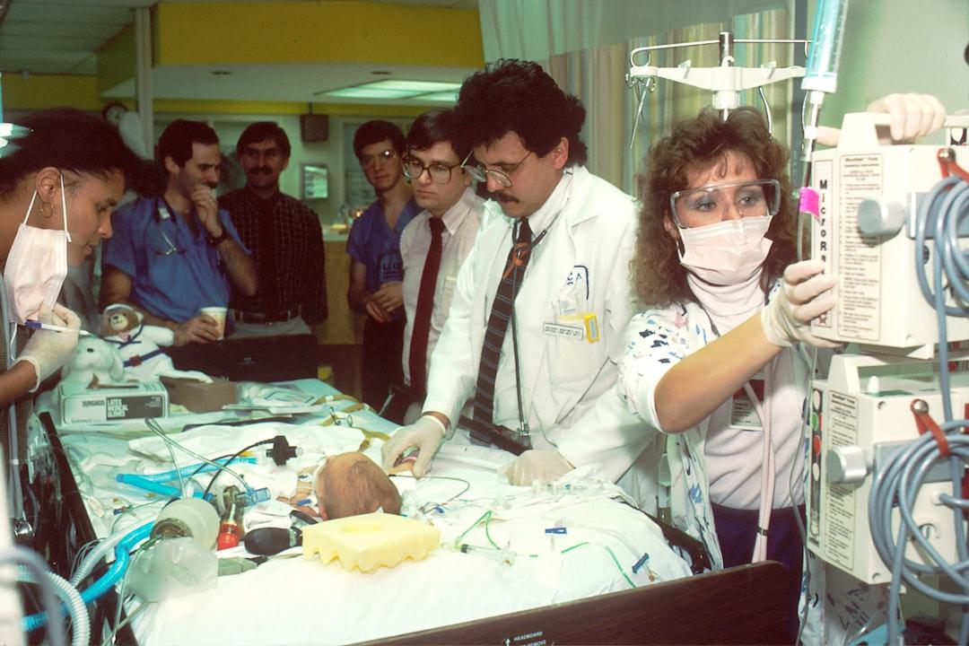 People beside baby lying on bed with medical apparatuses from National Cancer Institute on Unsplash