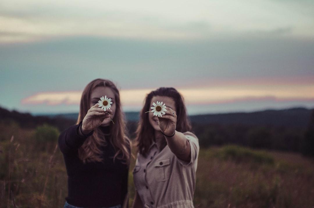 Two women holding flowers from Sam McNamara on Unsplash