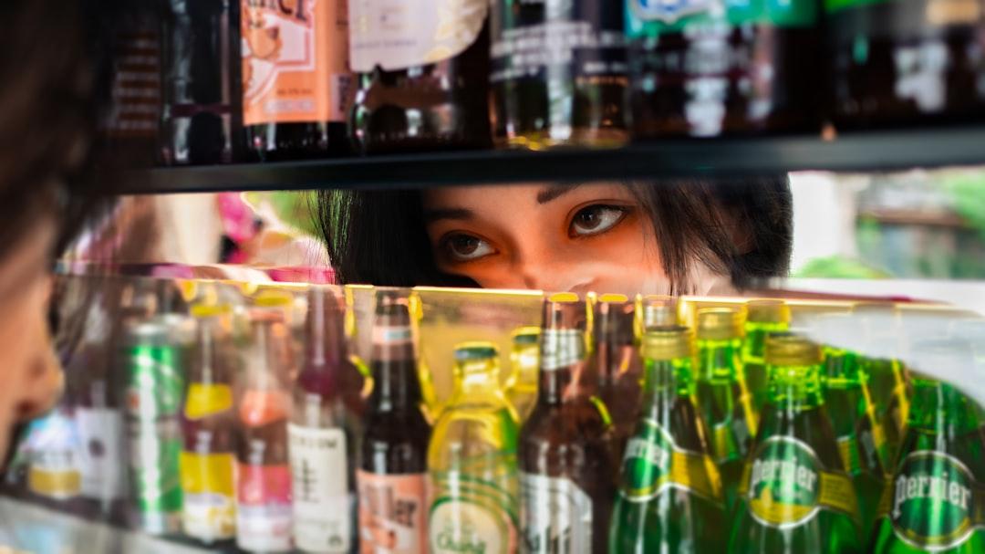 A woman looking at a shelf of beer bottles from Creedi Zhong on Unsplash Mù lòa từ bệnh võng mạc tiểu đường
