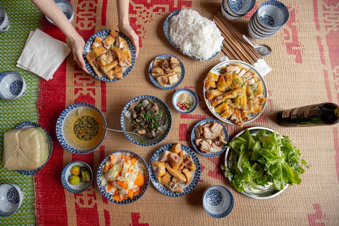 A table topped with bowls of food and plates of food from Duong Thinh on Unsplash Ăn uống hợp lý giúp tăng cường sức khỏe dịp Tết